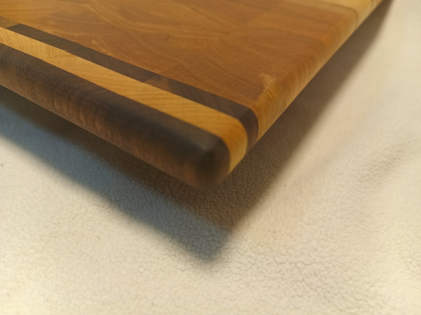 vtw versatile trees woodwork corner view of a thin, large size end grain cutting board made with walnut, maple, oak, and birch. Perfect for a home or professional chef, this board provides a usable work area without raising the work surface very far above the counter top