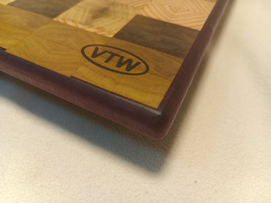 vtw versatile trees woodwork corner view of a thin, large size end grain cutting board made with purple heart walnut, Hemlock, and Poplar. Perfect for a home or professional chef, this board provides a usable work area without raising the work surface very far above the counter top and softer woods are easier on expensive knives