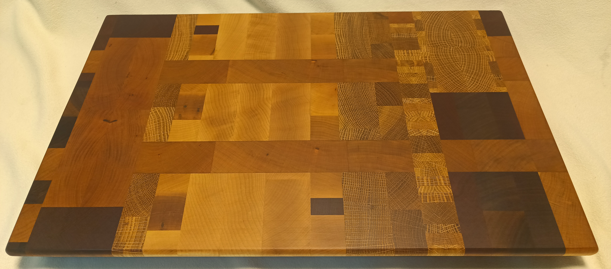 vtw versatile trees woodwork main view of a thin, large size end grain cutting board made with walnut, maple, mahogany, oak, and cherry. Perfect for a home or professional chef, this board provides a usable work area without raising the work surface very far above the counter top