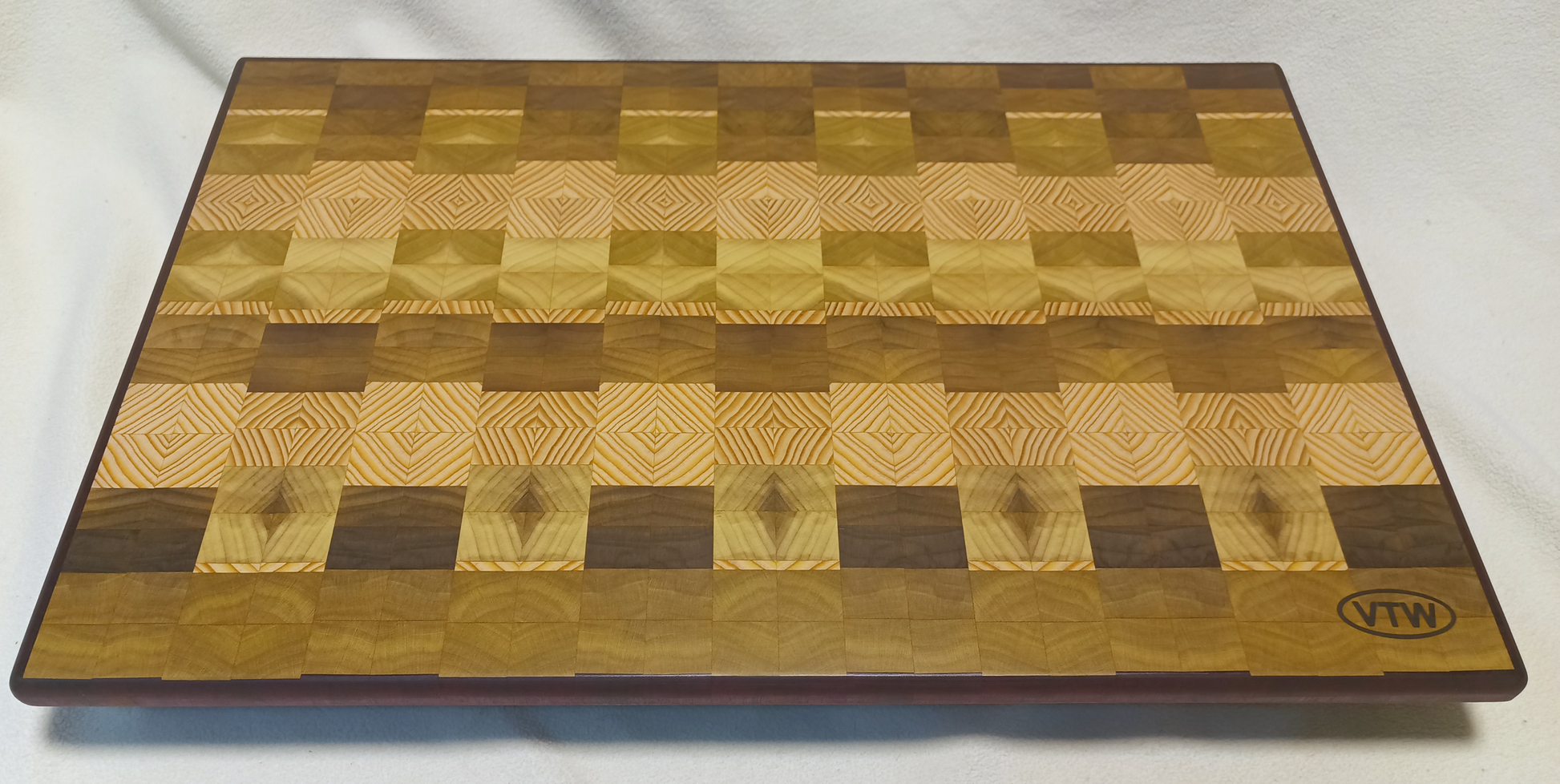 vtw versatile trees woodwork main view of a thin, large size end grain cutting board made with purple heart walnut, Hemlock, and Poplar. Perfect for a home or professional chef, this board provides a usable work area without raising the work surface very far above the counter top and softer woods are easier on expensive knives
