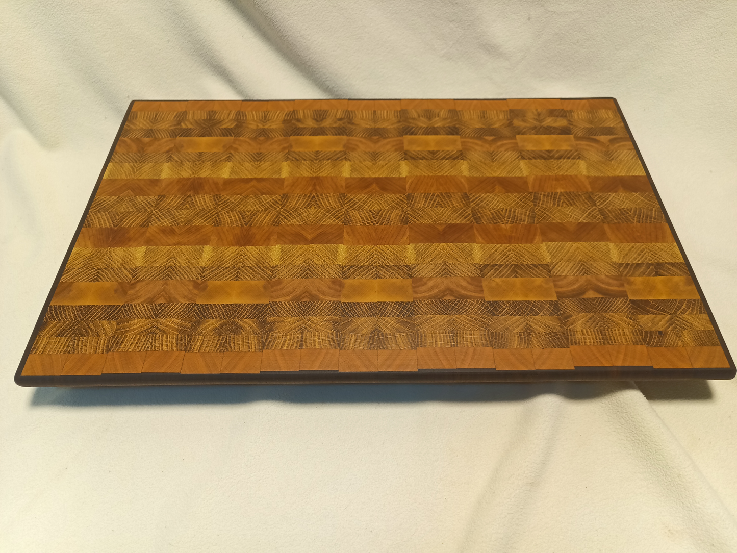 vtw versatile trees woodwork main view of a thin, large end grain cutting board made with walnut, oak, and cherry. Perfect for a home or professional chef, this board provides a large work area without raising the work surface very far above the counter top