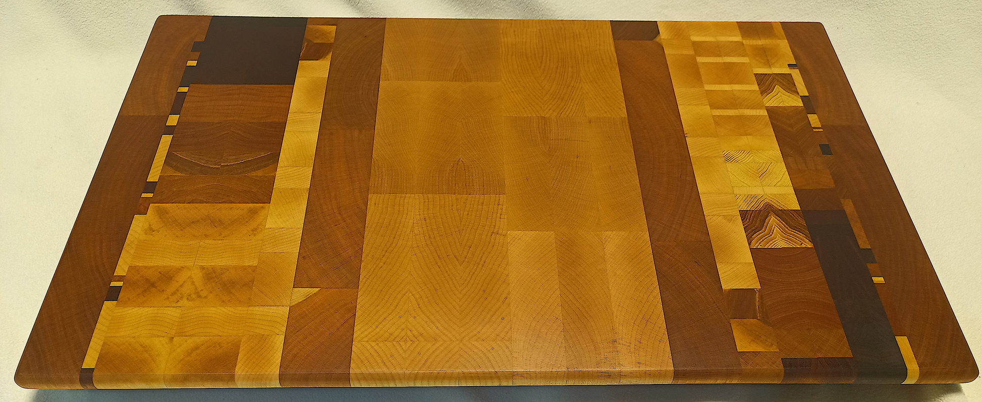 vtw versatile trees woodwork main view of a thin, large size end grain cutting board made with walnut, hickory, maple, mahogany, and cherry. Perfect for a home or professional chef, this board provides a usable work area without raising the work surface very far above the counter top