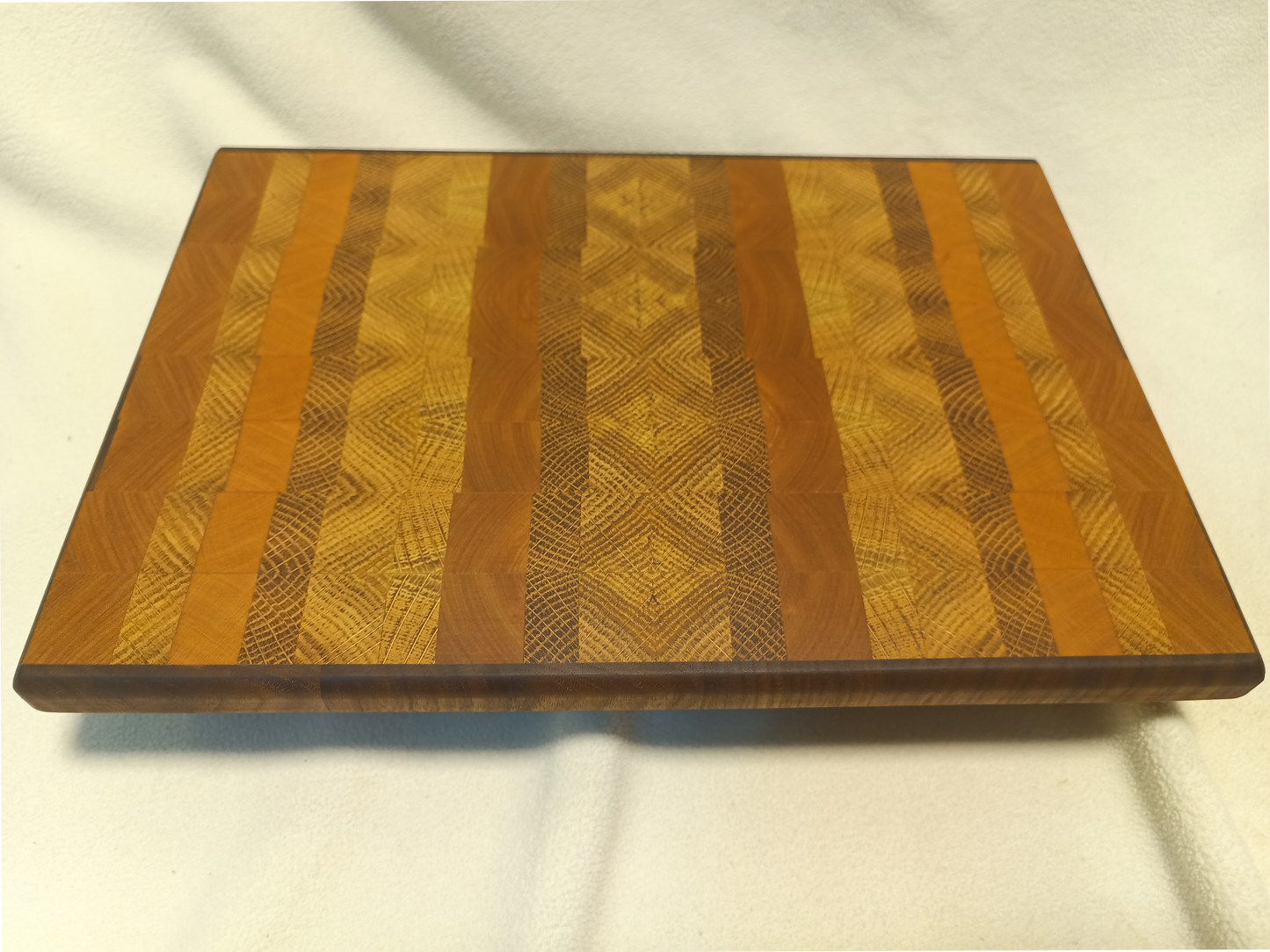 vtw versatile trees woodwork main view of a thin, medium size end grain cutting board made with walnut, oak, and cherry wood. Perfect for a home or professional chef, this board provides a usable work area without raising the work surface very far above the counter top