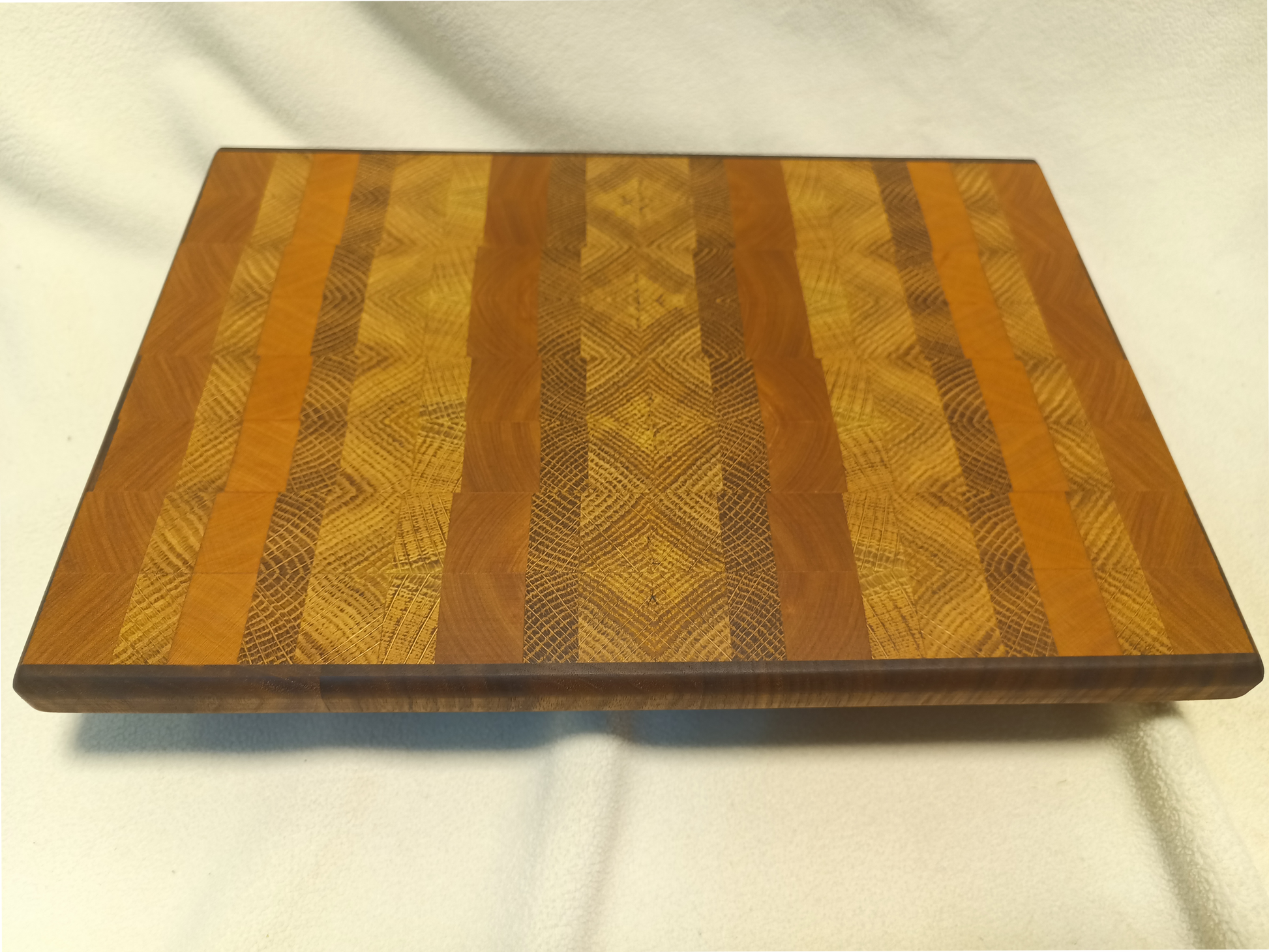 vtw versatile trees woodwork main view of a thin, medium size end grain cutting board made with walnut, oak, and cherry wood. Perfect for a home or professional chef, this board provides a usable work area without raising the work surface very far above the counter top