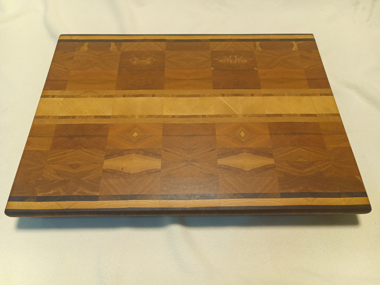 vtw versatile trees woodwork corner view of a thin, large size end grain cutting board made with walnut, maple, oak, and birch. Perfect for a home or professional chef, this board provides a usable work area without raising the work surface very far above the counter top
