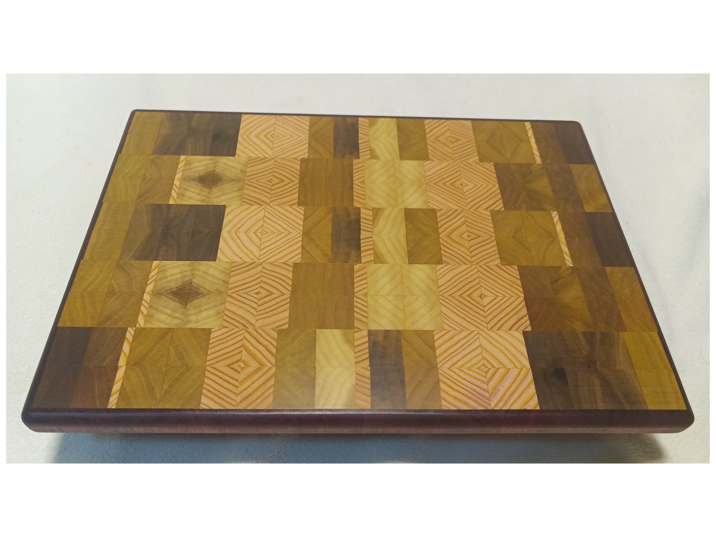 vtw versatile trees woodwork main view of a thin, large size end grain cutting board made with purple heart walnut, Hemlock, and Poplar. Perfect for a home or professional chef, this board provides a usable work area without raising the work surface very far above the counter top and softer woods are easier on expensive knives