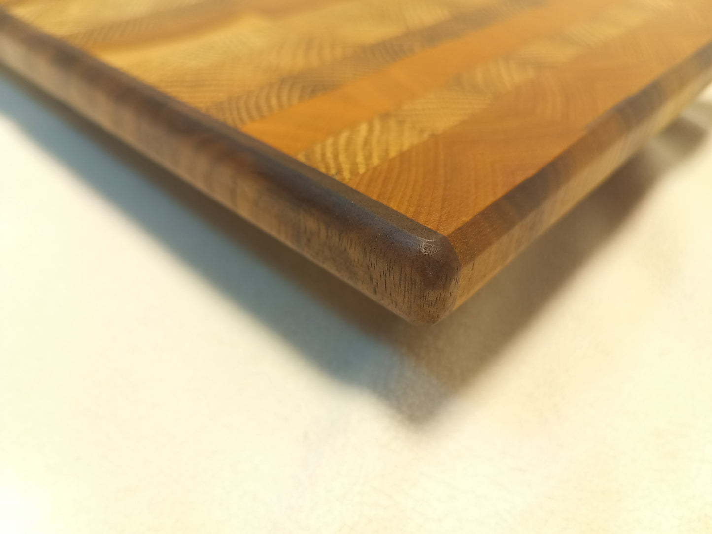 vtw versatile trees woodwork corner view of a thin, medium size end grain cutting board made with walnut, oak, and cherry wood. Perfect for a home or professional chef, this board provides a usable work area without raising the work surface very far above the counter top